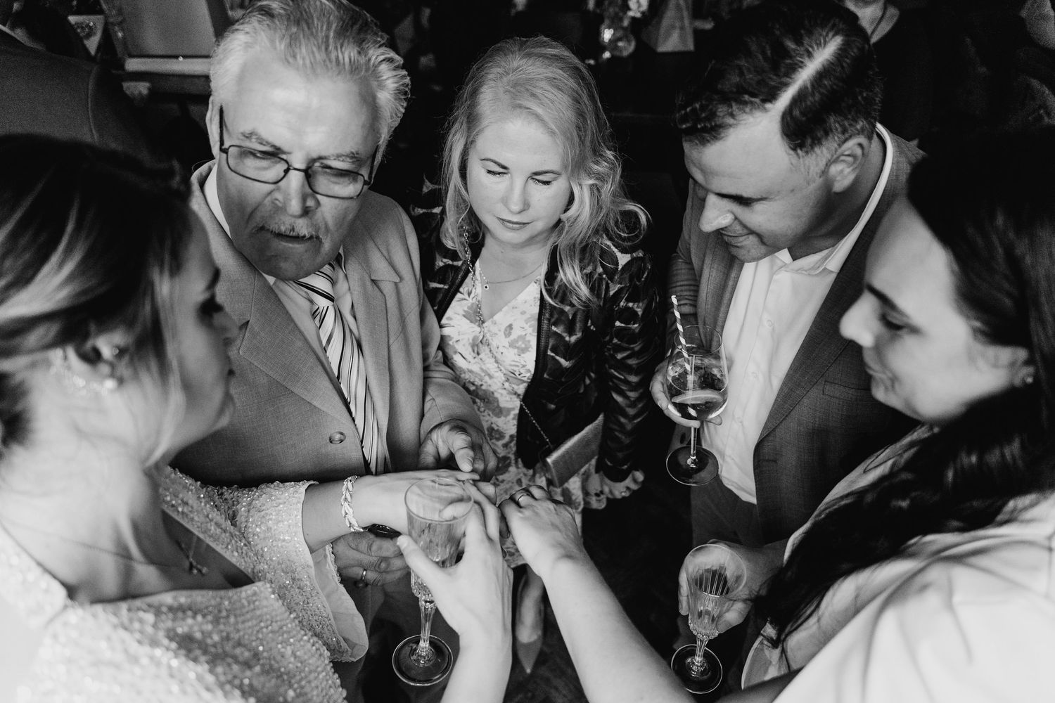 A black and white photo showing wedding guests looking at something being shared in the middle of the group. House Dublin Wedding Photograph