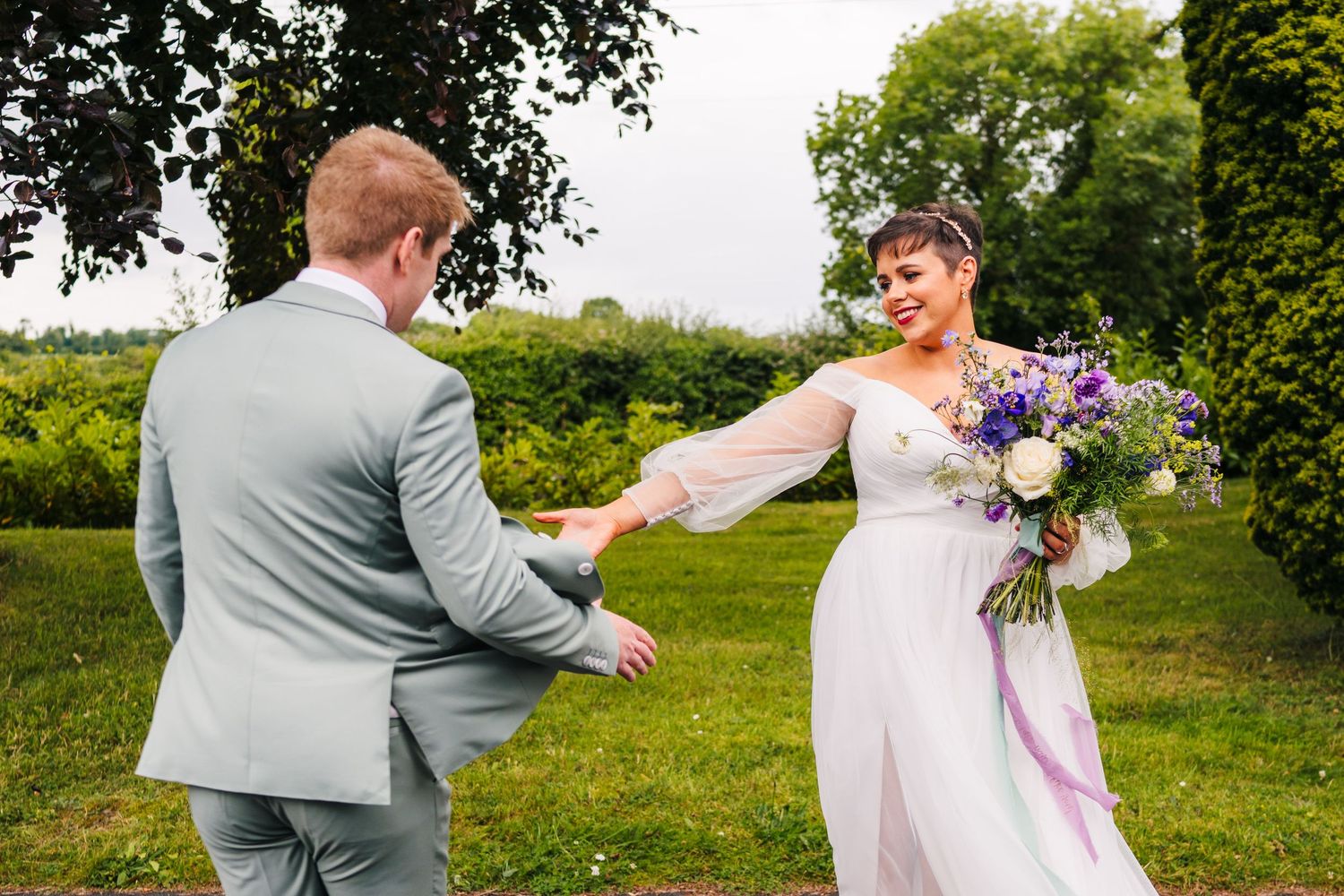 Millhouse slane wedding photographer duRomantic outdoor wedding photoshoot in a lush green field with the couple sharing an intimate moment.