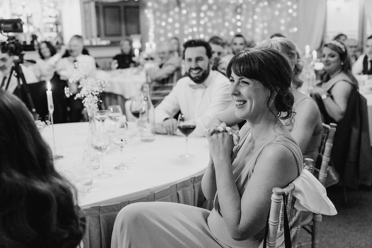 Castle Leslie Wedding Photographer Dublin A black and white reception scene with guests seated at tables under twinkling lights.