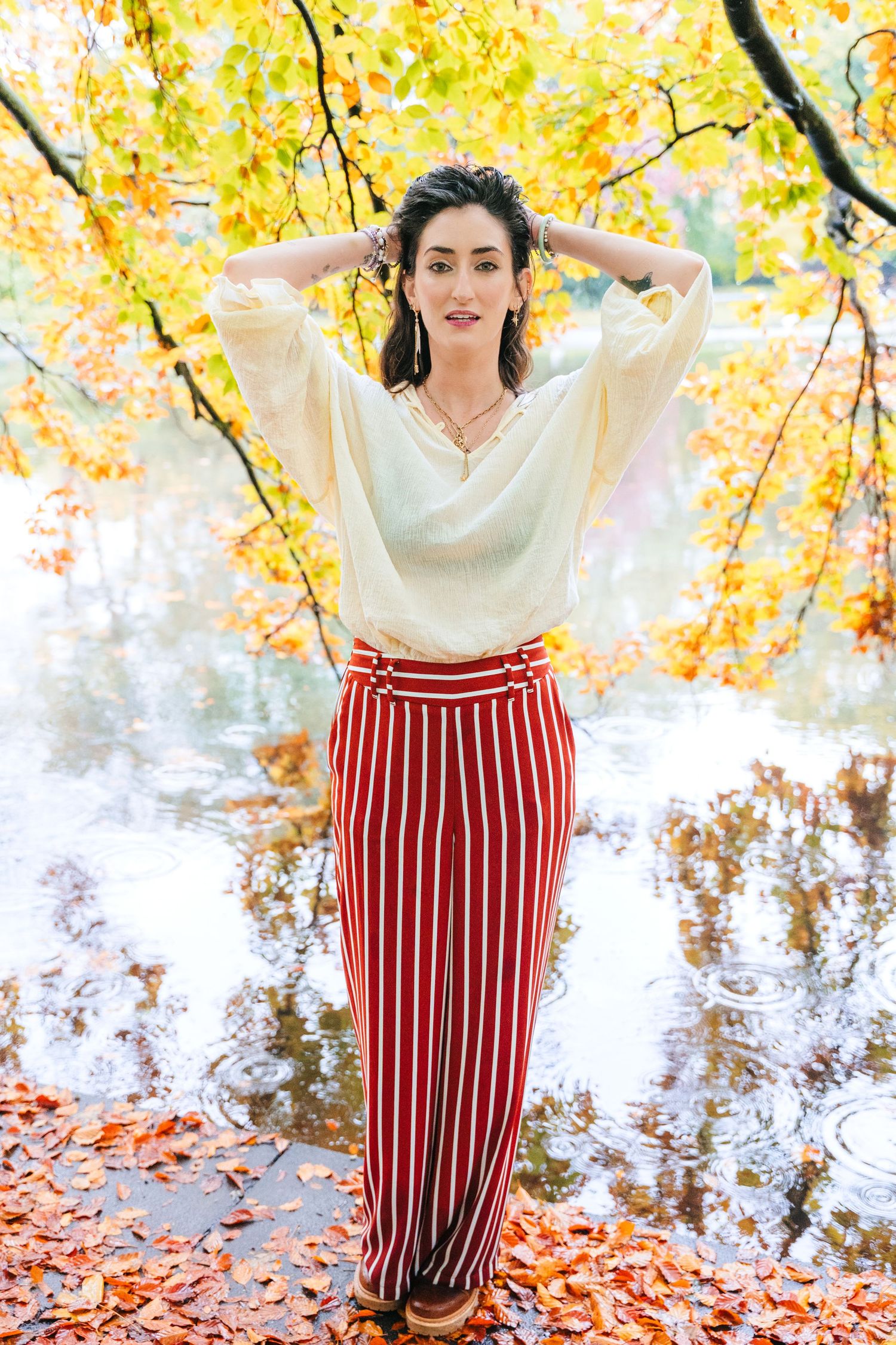 Fall fashion portrait with striped pants and cream blouse against golden autumn foliage. professional headshots dublin photographer
