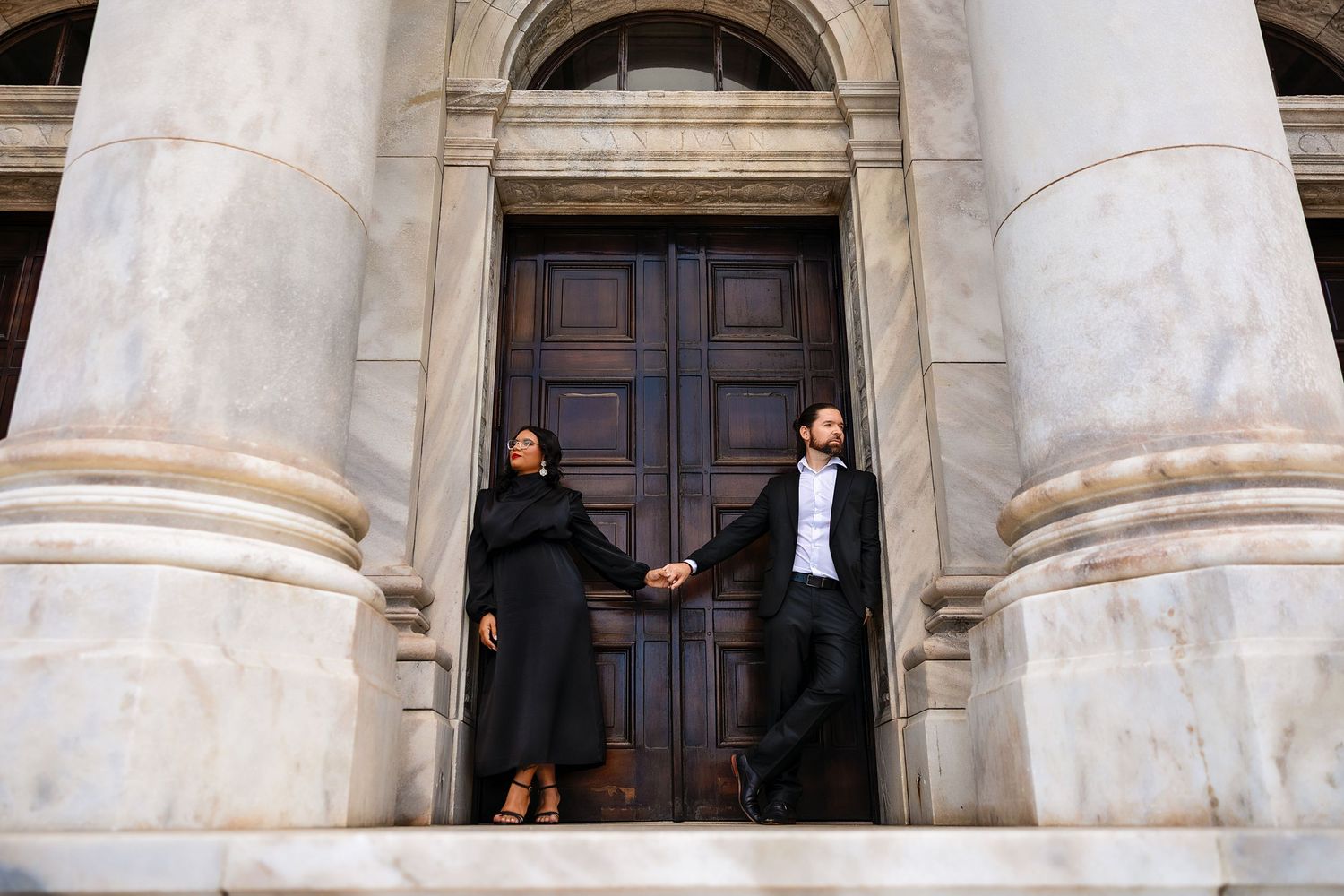 A series of photos showing people posing between large classical stone columns of a historic building entrance.