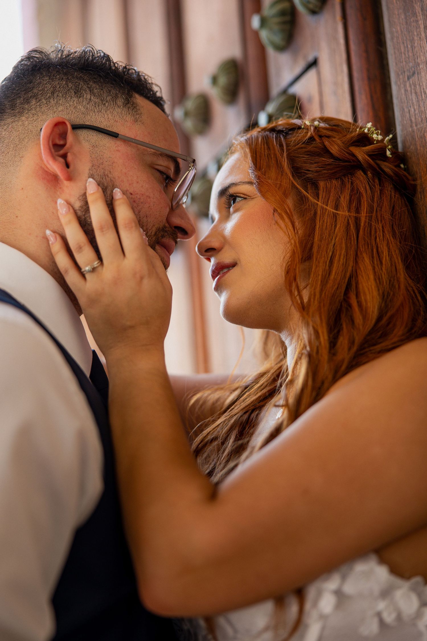 A bride and groom share an intimate moment, gazing into each others eyes during their wedding day.