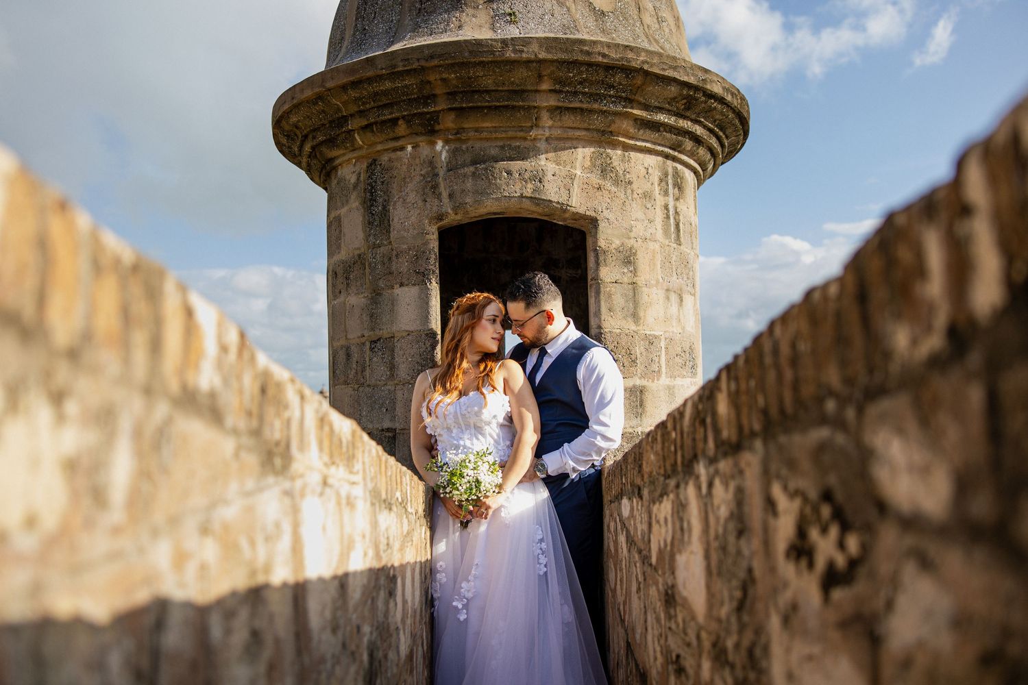Wedding portrait framed by historic stone architecture with beautiful natural lighting.