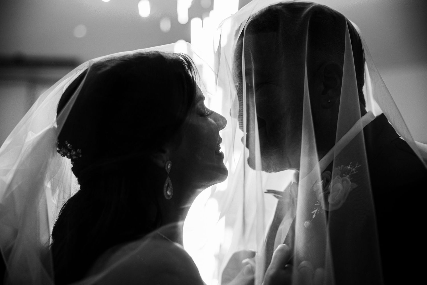Silhouettes of figures in dramatic black and white lighting create an artistic composition against a bright background.