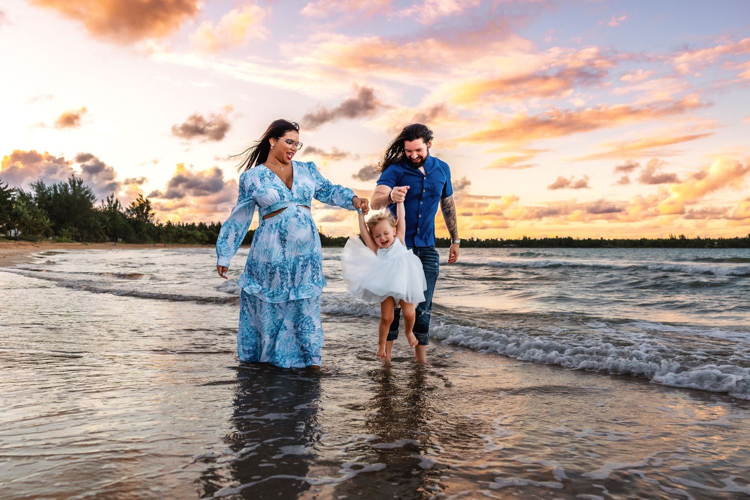 Group enjoying sunset beach walk together with ocean waves and dramatic orange sky.