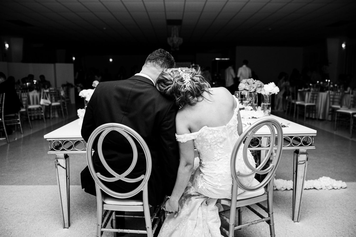 Black and white reception photos showing wedding guests seated at tables in a dimly lit venue.