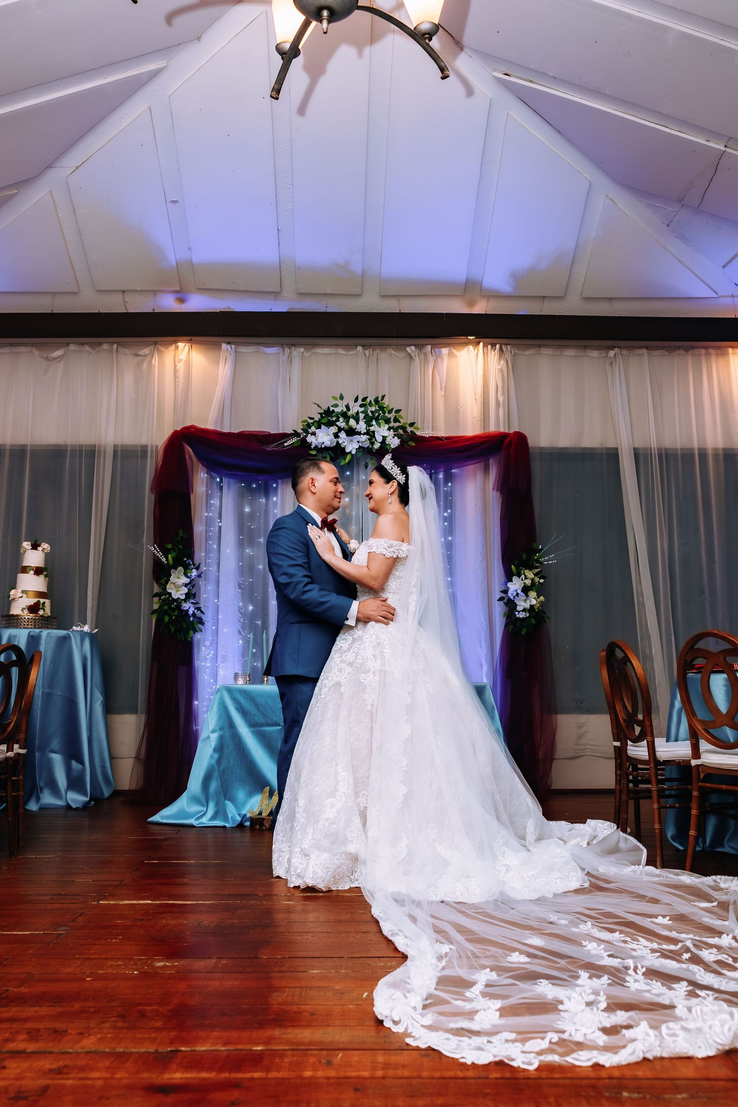 A romantic first dance sequence between newlyweds in a white wedding dress and navy suit at an elegant indoor venue.