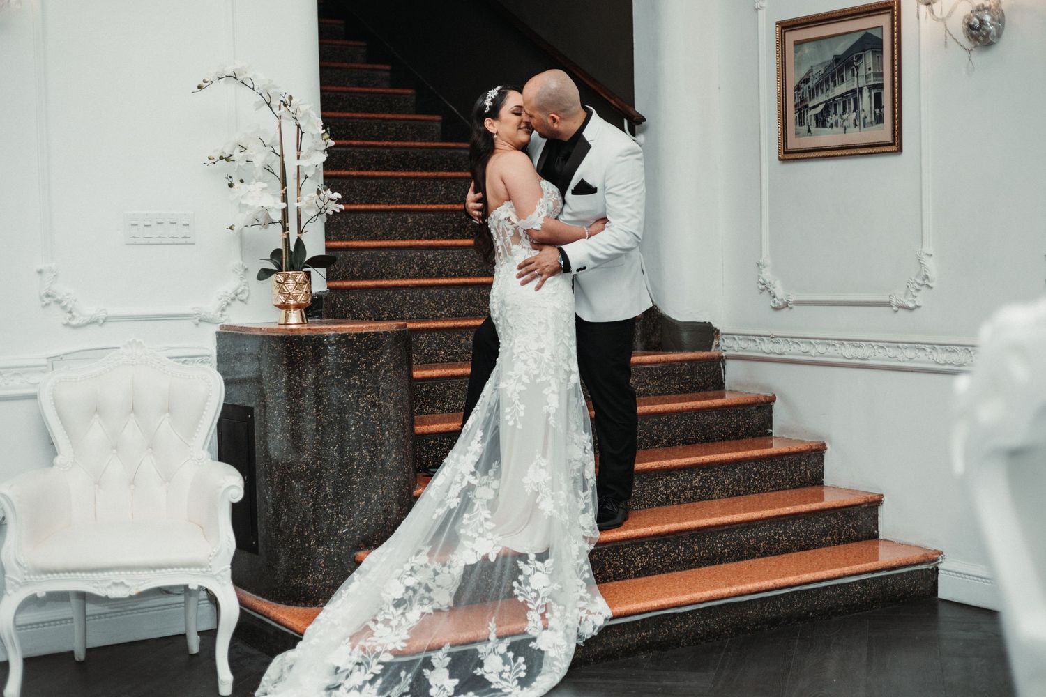 Elegant wedding venue interior with wooden staircase and white decor details.