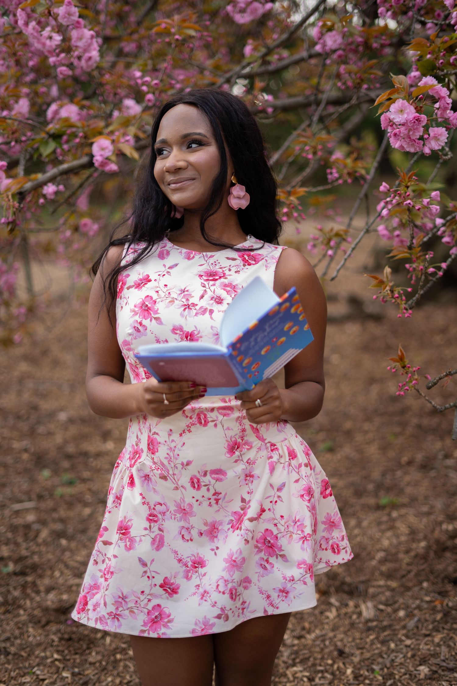 A floral dress photoshoot among blooming pink cherry blossoms on a spring day. central park cherry blossom