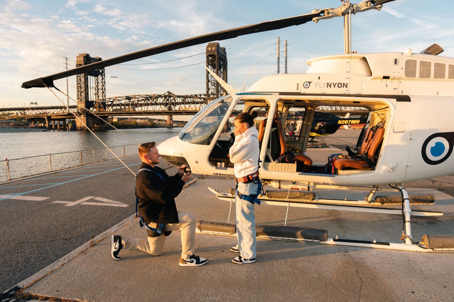 Small private aircraft parked in a row at an airport during sunset with golden light illuminating their sides. flynyon helicopter proposal