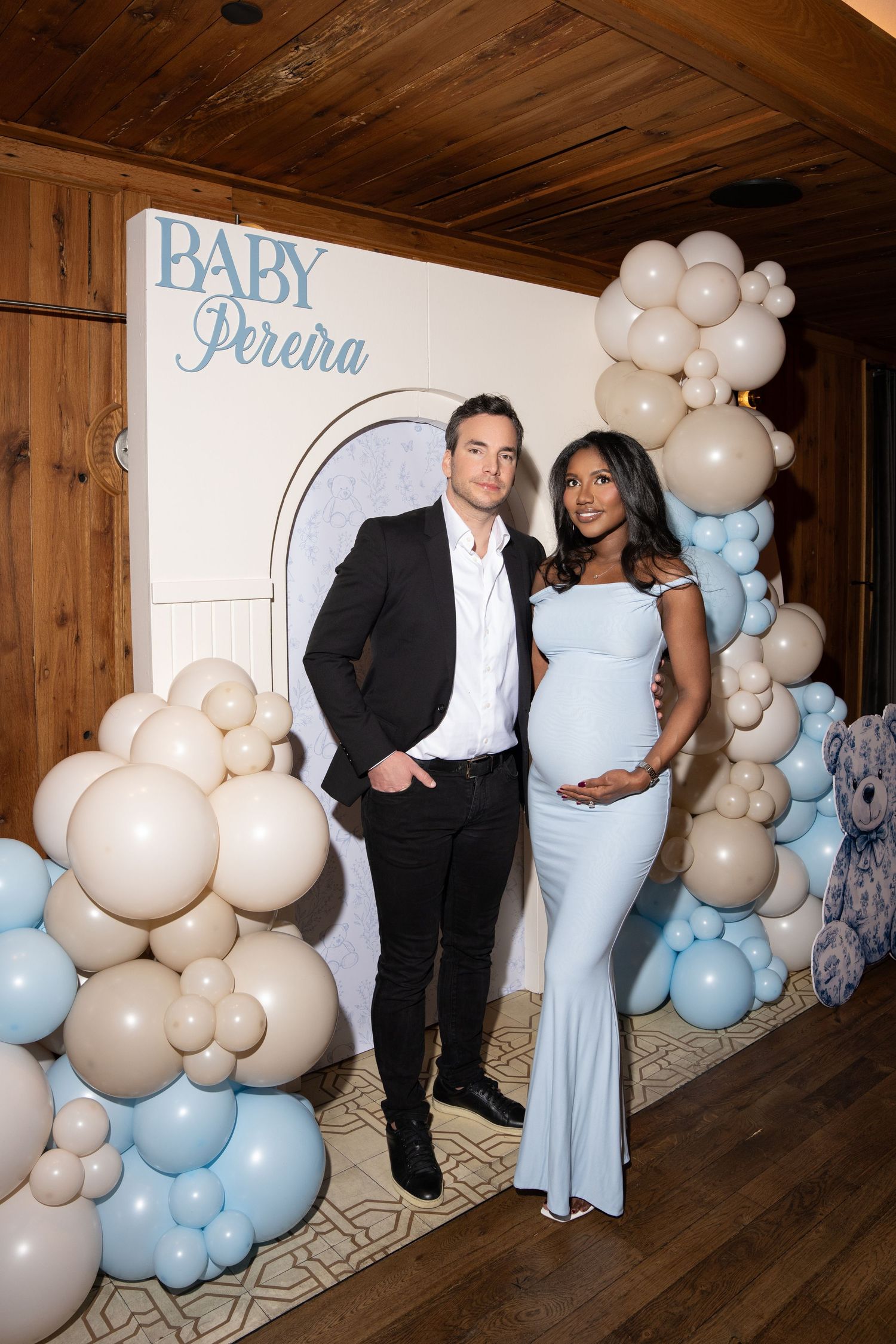 Elegant baby shower celebration with white and blue balloon arch decorations against wooden wall interior. new york