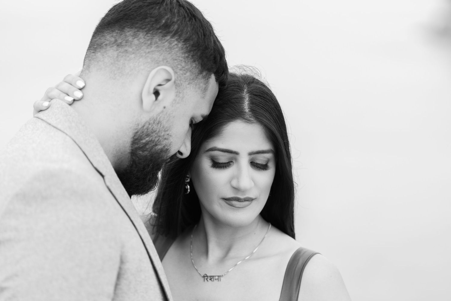 Black and white intimate portrait showing a tender moment between a couple during a romantic photoshoot.