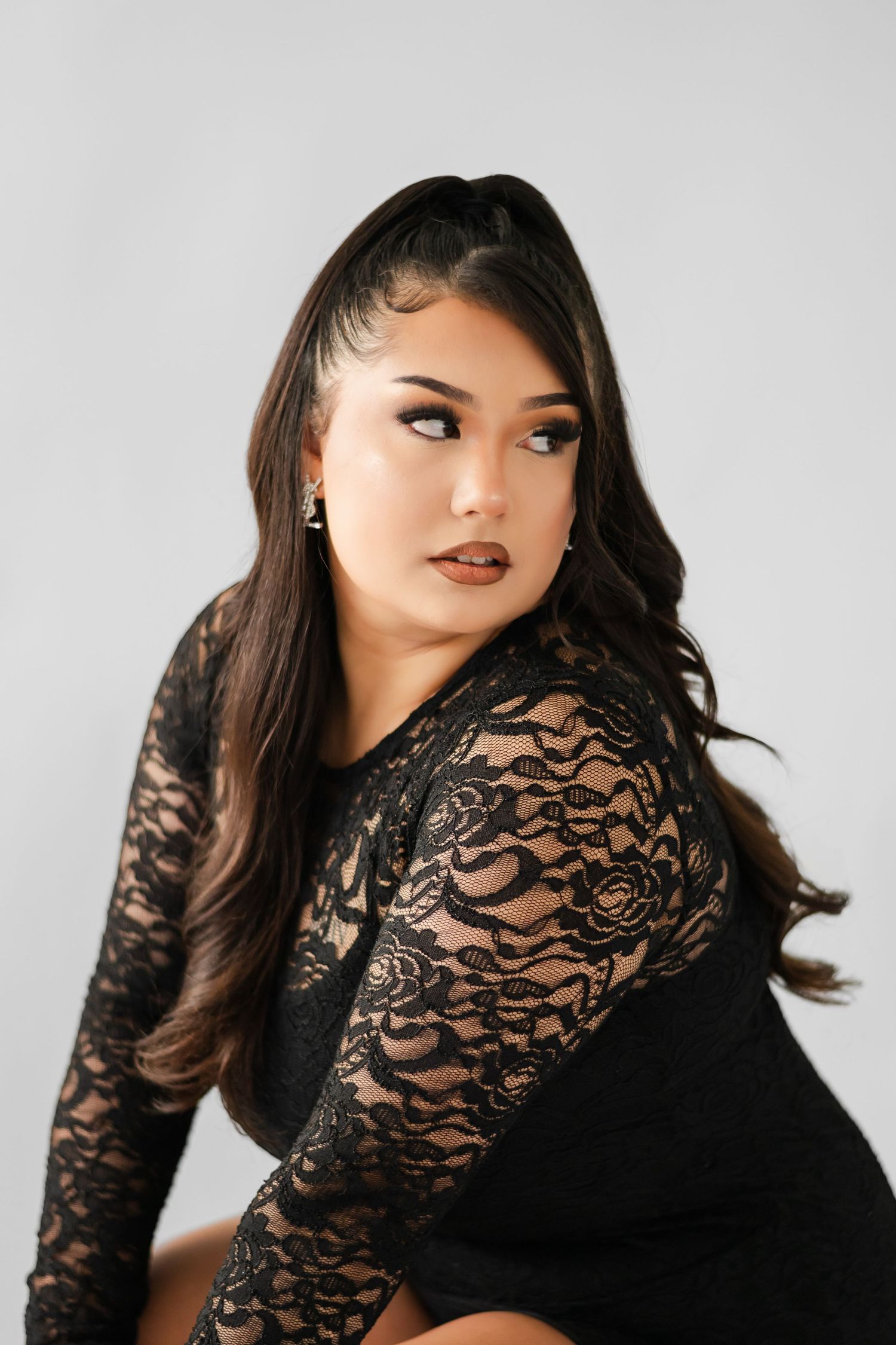 Studio portrait featuring a black lace long-sleeve top against a light gray background. Sunnyside birthday photo session.