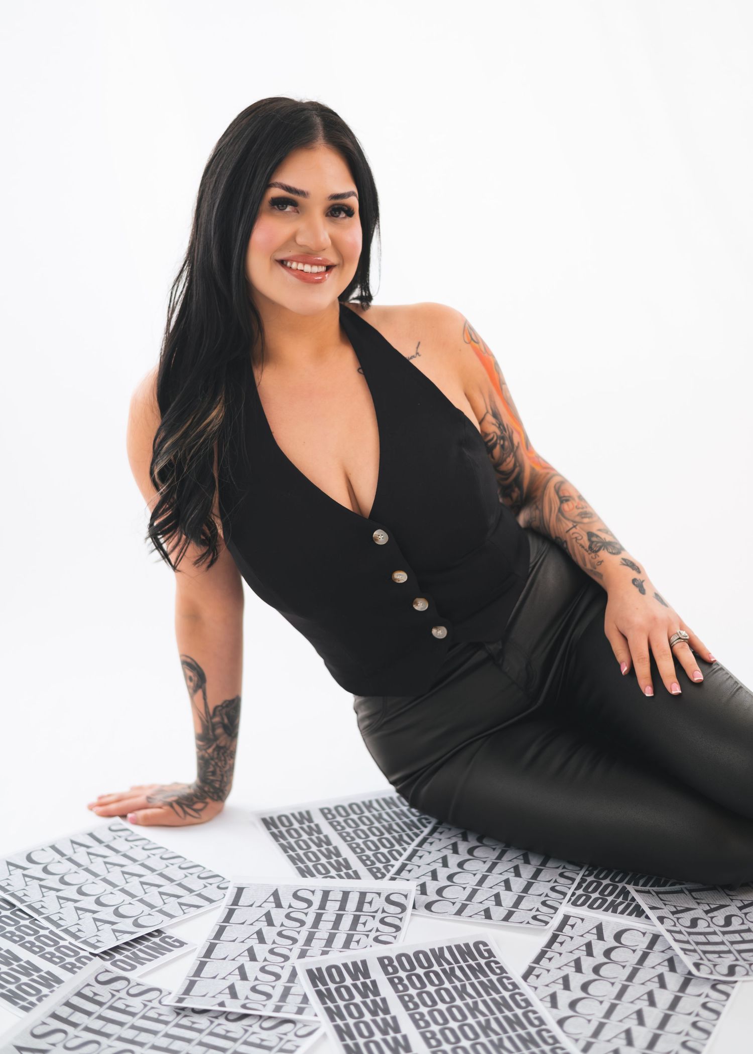 Woman in black dress poses on geometric black and white patterned floor mat with text reading 'Lashes'.