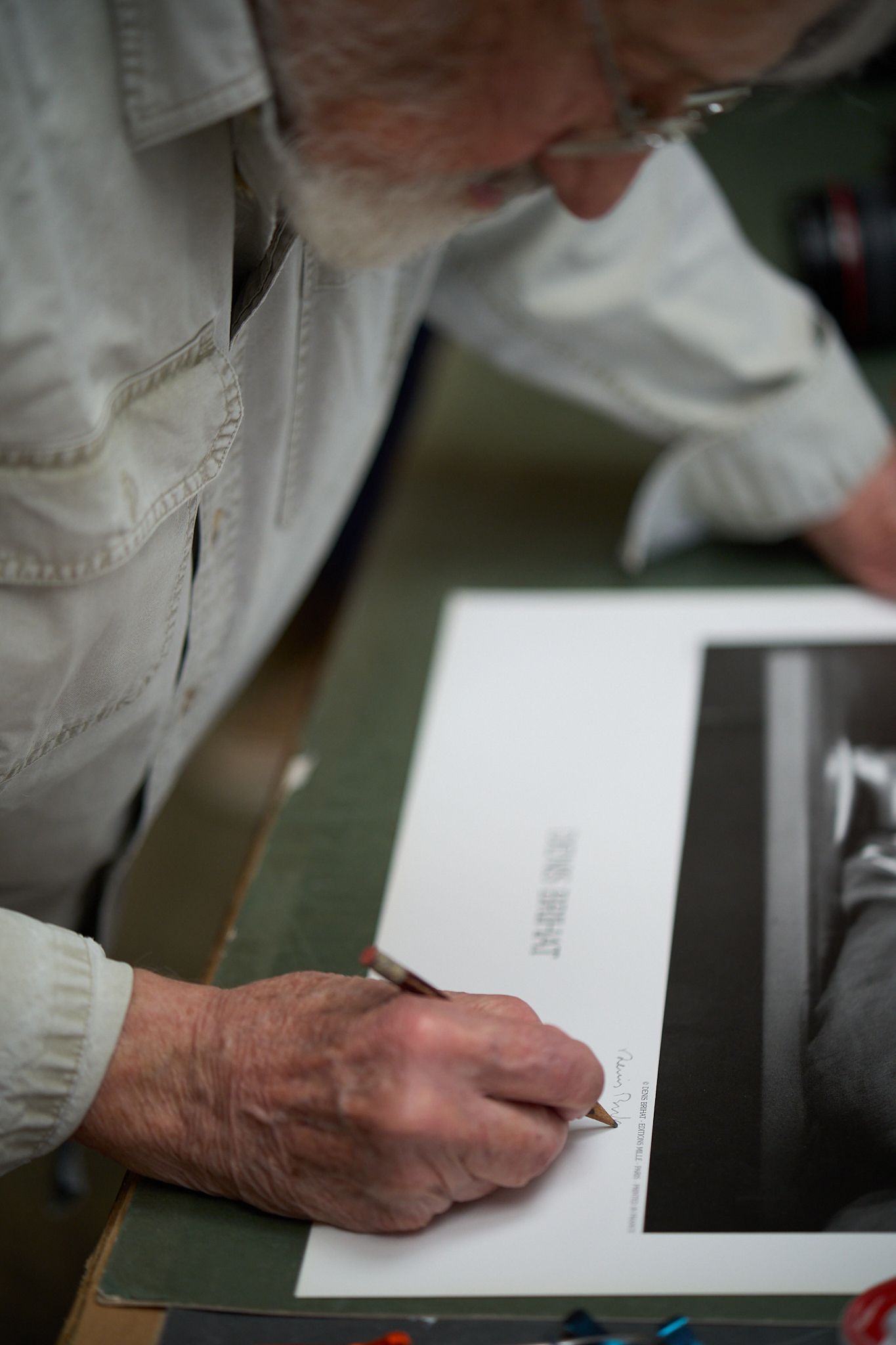 Travel and editorial photography, Provence, France, Photographer Denis Brihat signing a print, poster