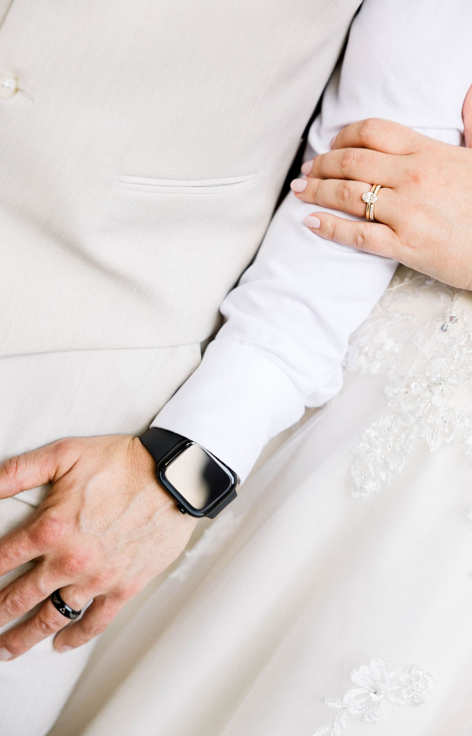 Wedding detail shots showing rings and lace dress details against light formal attire.