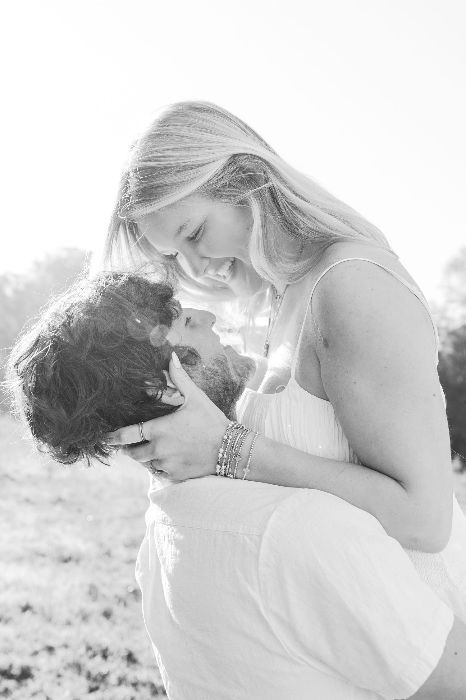 Black and white intimate portrait of couple sharing tender moment in natural light.