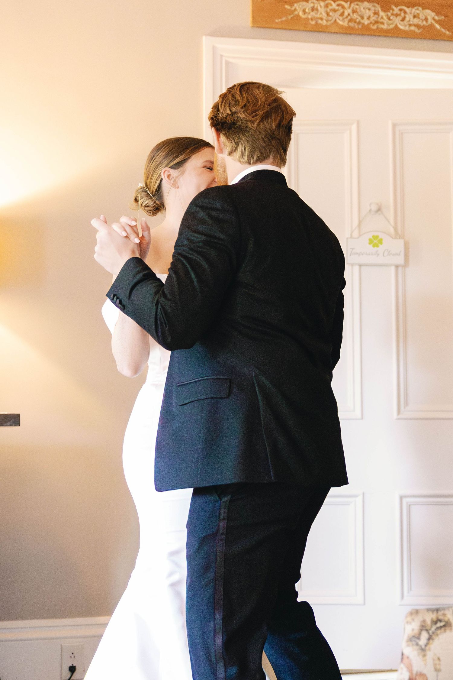 Couple sharing first dance in elegant indoor setting.