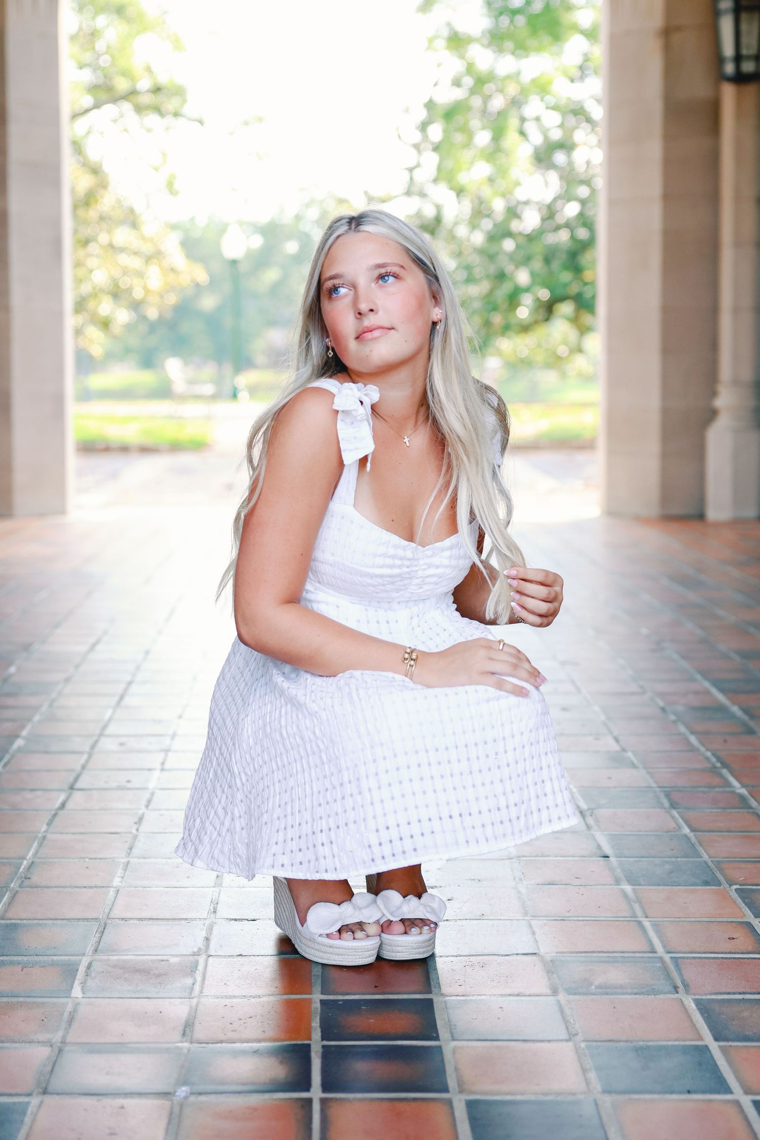 Set of five artistic photos showing poses on ornate tiled floor under covered porch with green foliage in background.