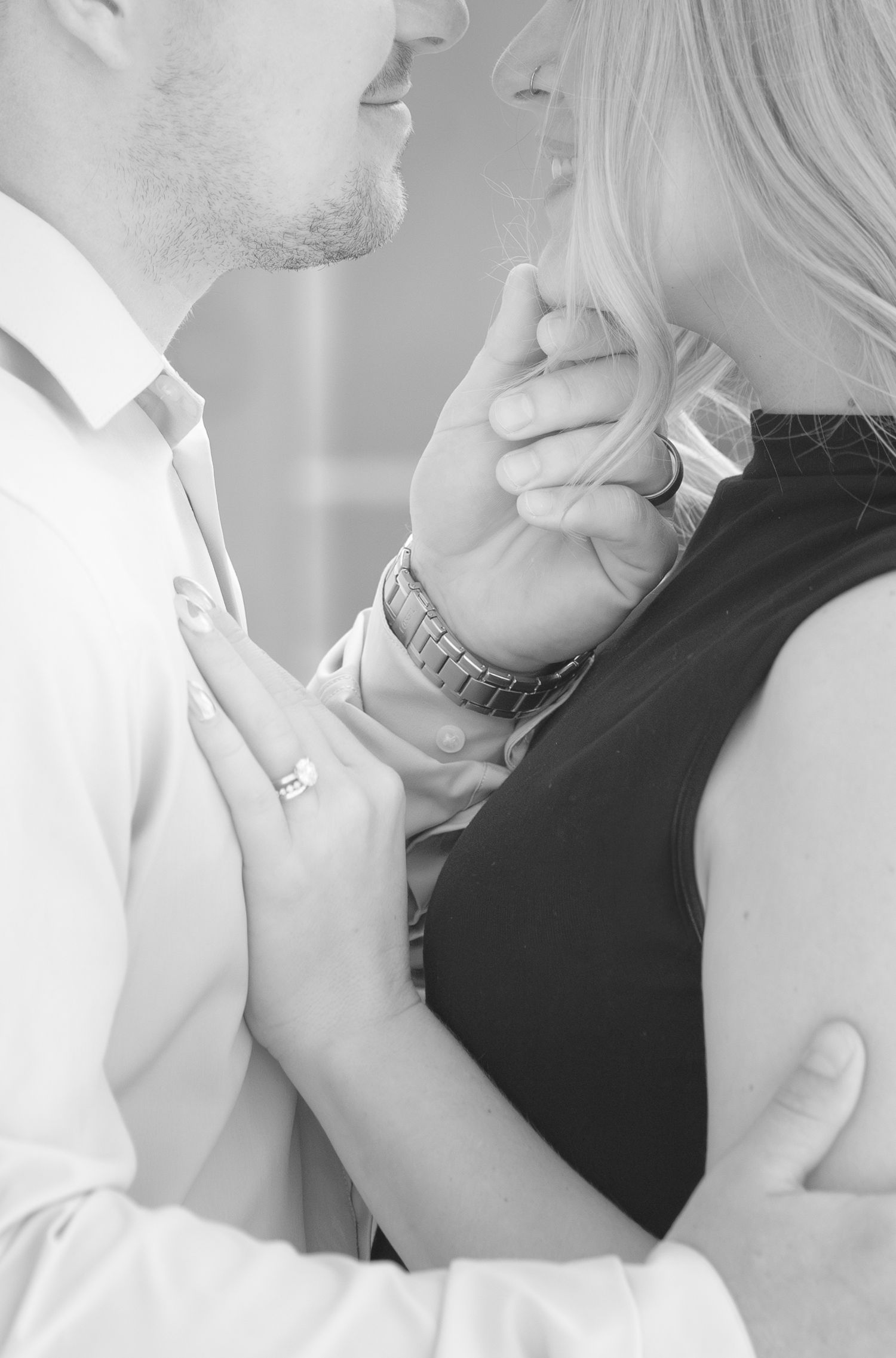 Black and white intimate portrait of couple in romantic embrace with soft lighting.