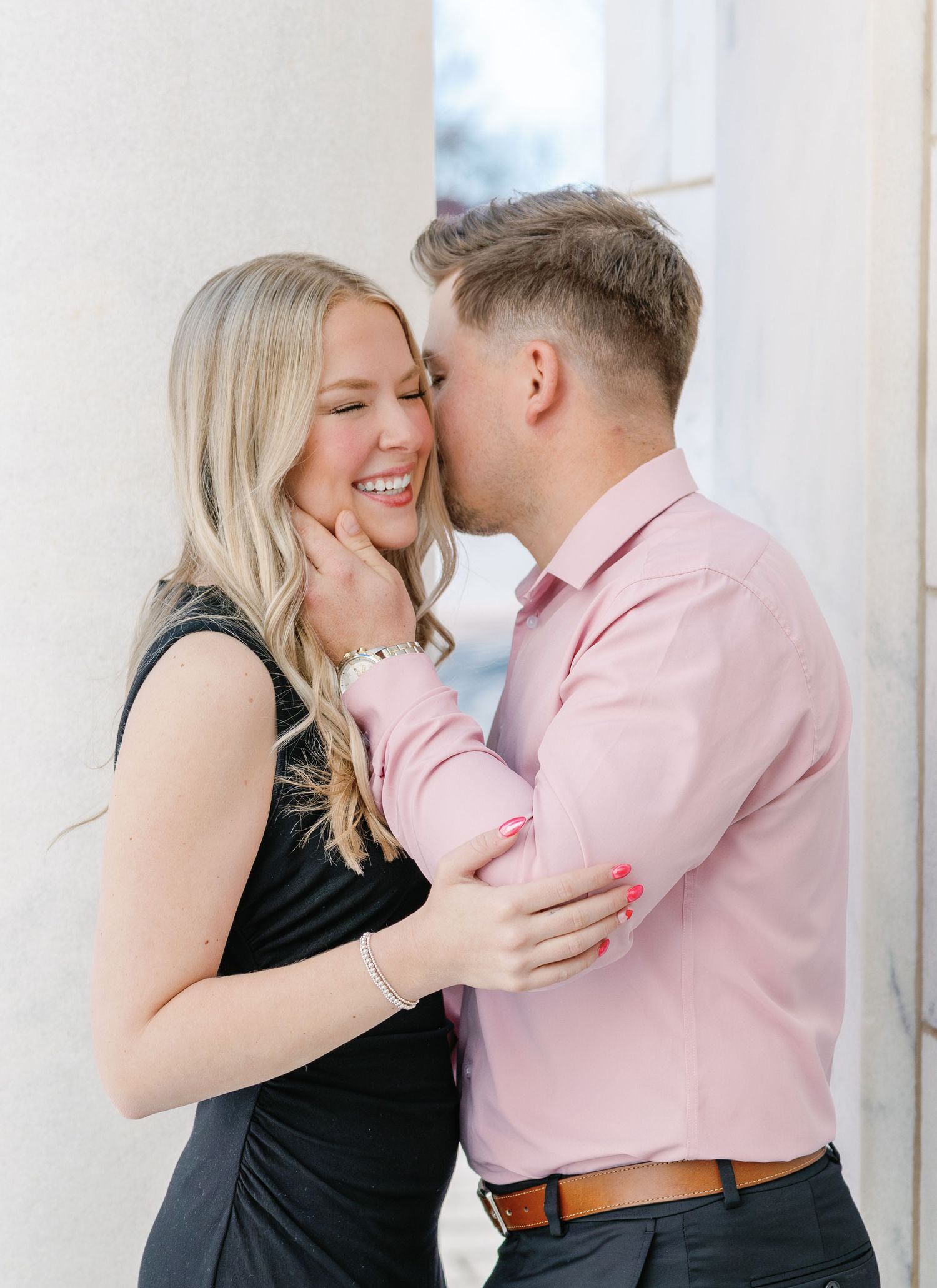 Romantic couple shares laughter and embrace while dressed in coordinating formal wear.