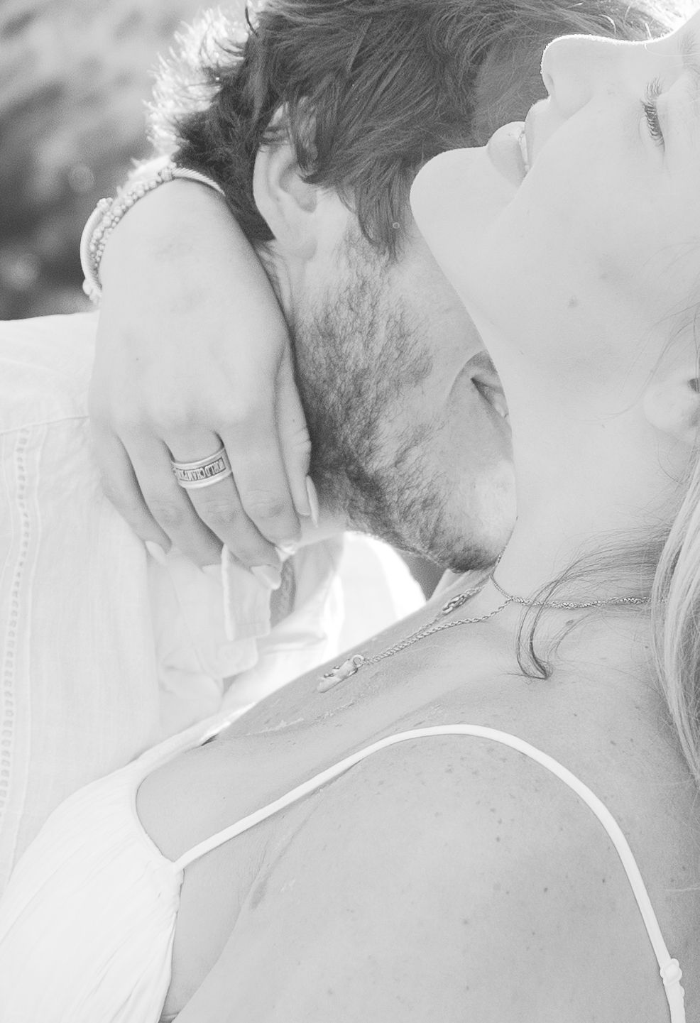 Intimate black and white portrait showing tender embrace between two people.