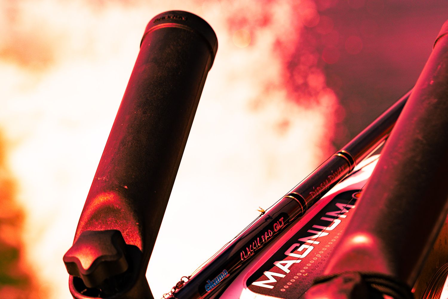 Silhouetted wine bottles lined up against a warm glowing background with orange and red hues.