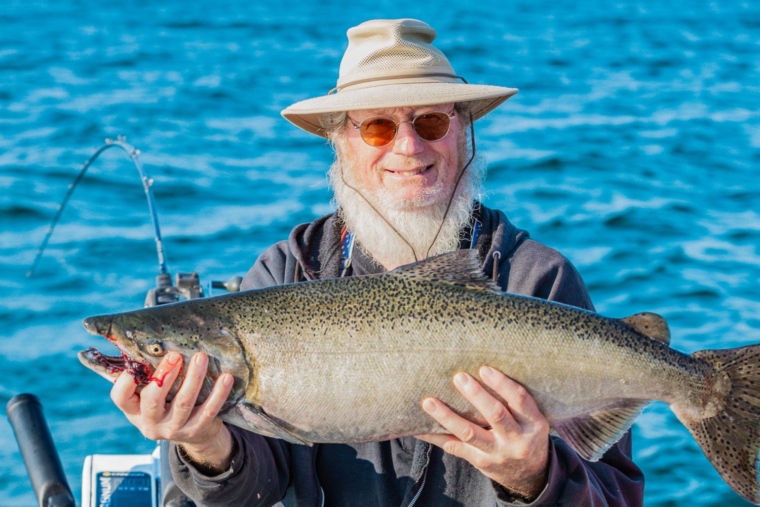 A series of fishing photos showing anglers displaying their freshly caught lake trout against bright blue water.