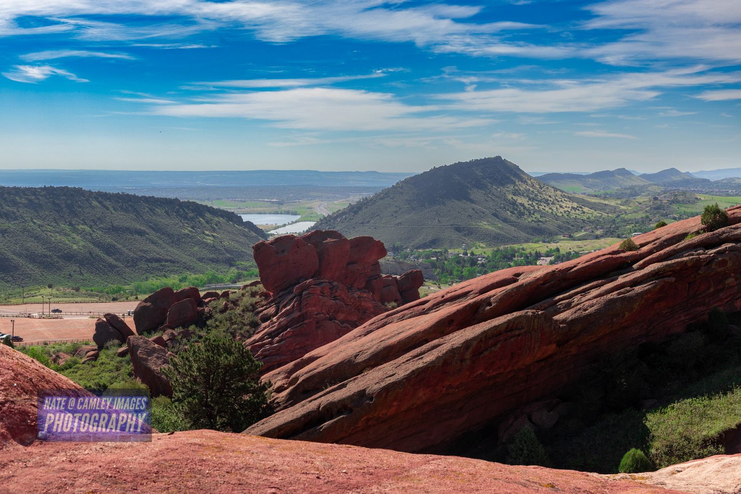 Red Rocks Amphitheatre in Colorado showcases dramatic sandstone formations against a bright blue mountain sky.