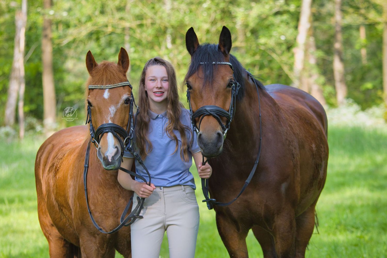 Trotse eigenaresse met haar twee pony's stralend in de natuur.