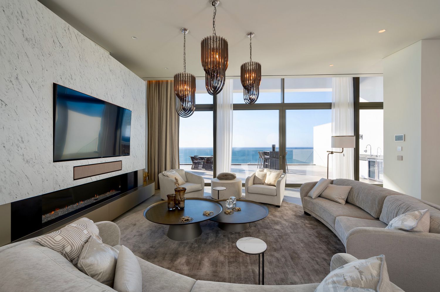 Spacious modern living room with ocean views, pendant lights, and comfortable seating in the Algarve, by Parallel Studios