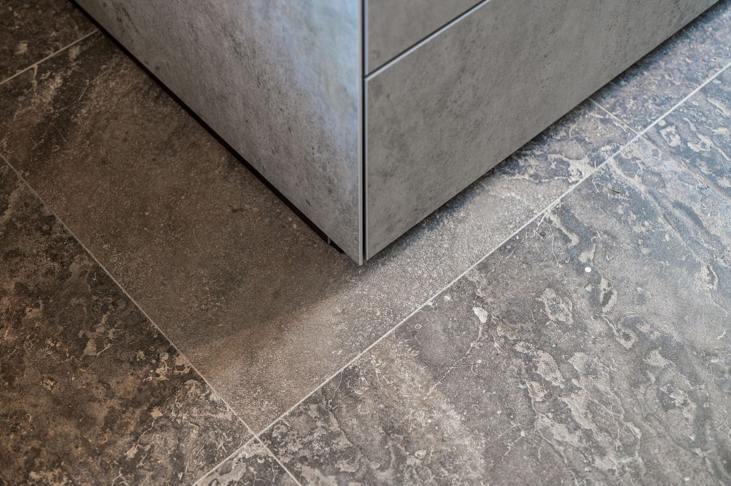 Close-up detail of textured stone flooring with angular geometric patterns, by Parallel Studios