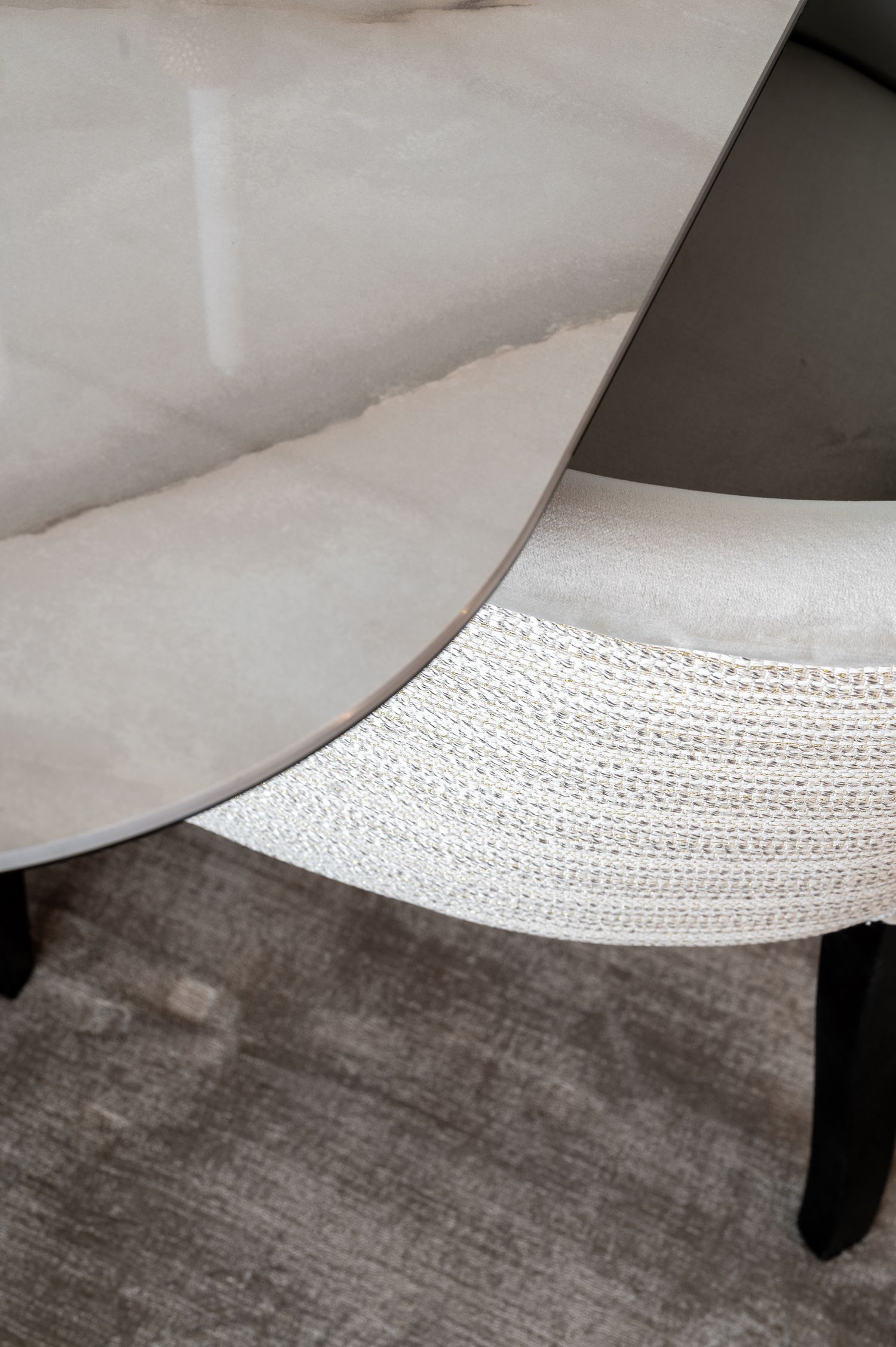 Detailed view of white textured fabric material meeting dark wooden surface.
