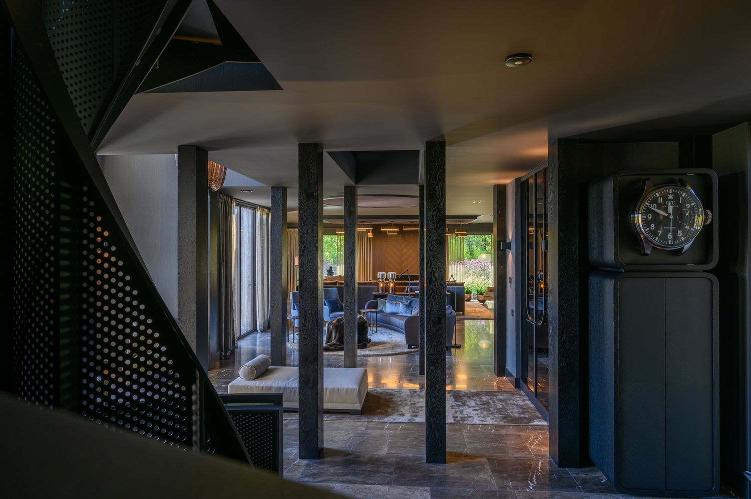Panoramic view of a modern indoor space with dark walls and natural lighting.