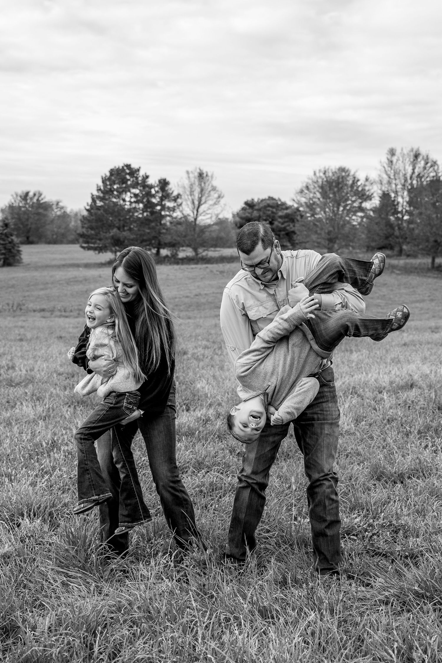 A playful sequence of black and white photos showing two people spinning and dancing together in a grassy field.