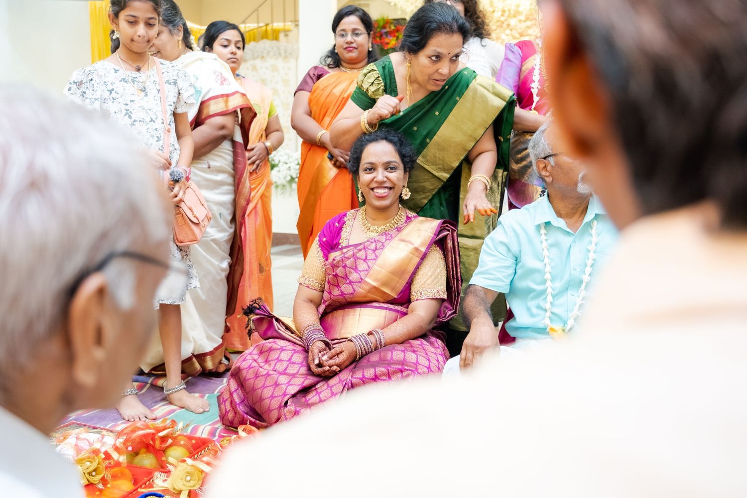 A traditional Indian baby shower ceremony with women in colorful saris gathered around.