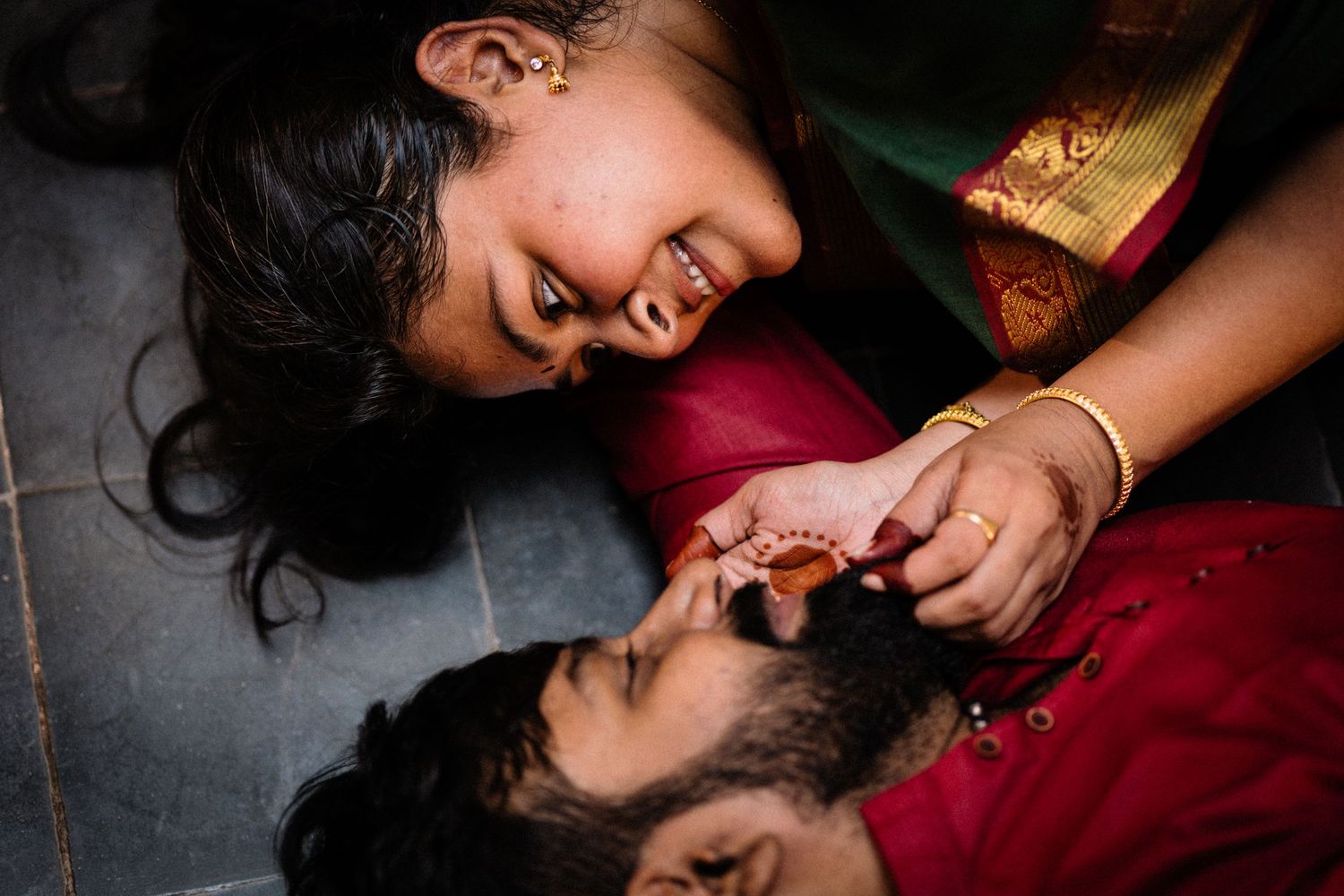 Two people share an intimate moment while lying on the ground together.