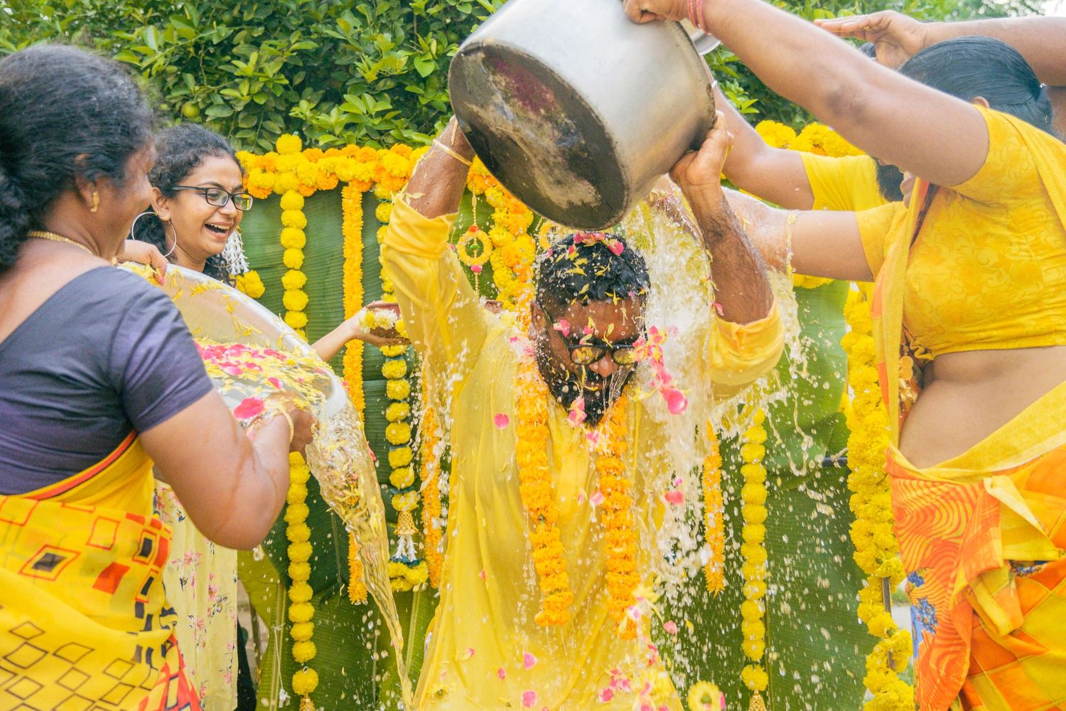 Traditional Haldi ceremony with turmeric water being poured during pre-wedding celebrations.