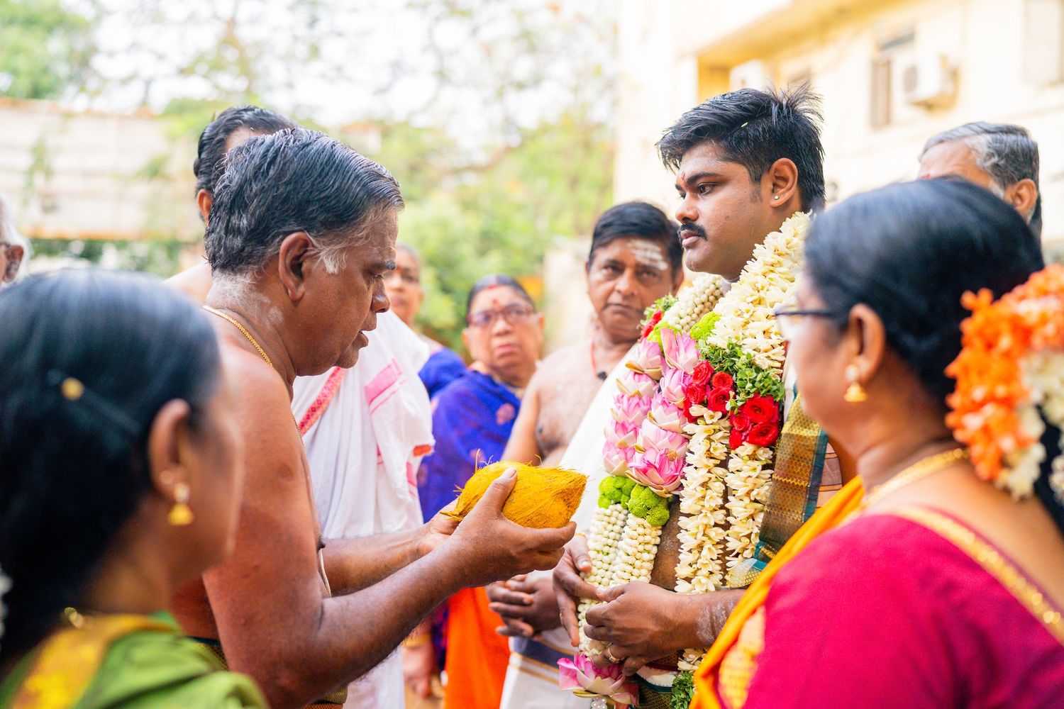 Traditional South Indian ceremony with floral garlands and ritual offerings being exchanged.