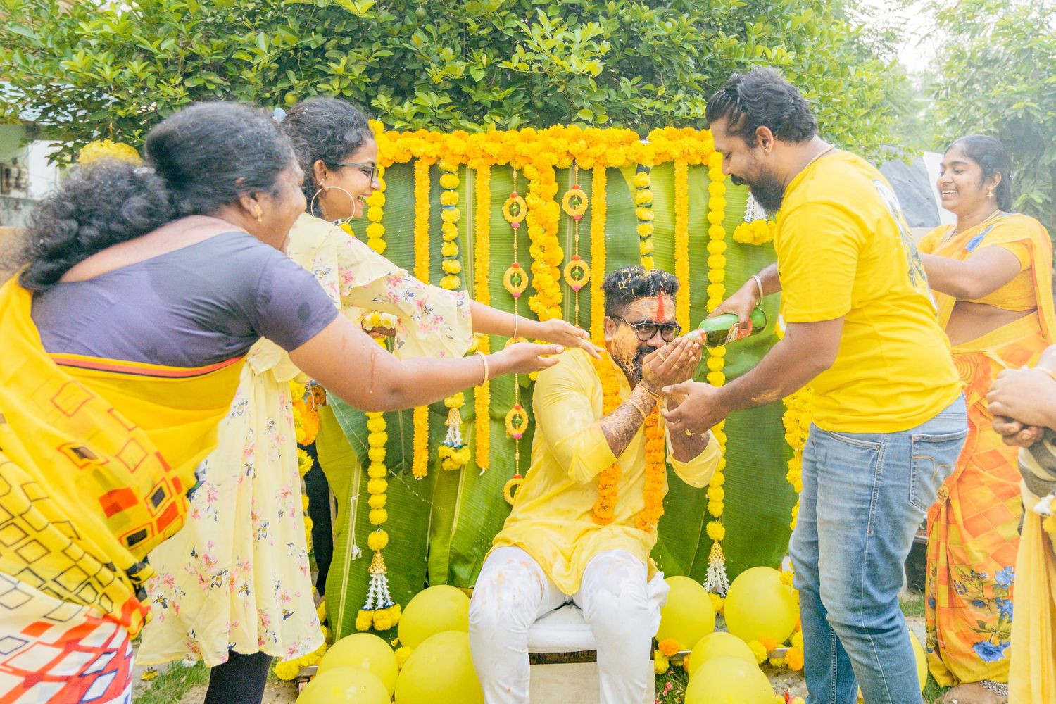 Festive gathering with yellow decorations and traditional ceremonies in an outdoor setting.