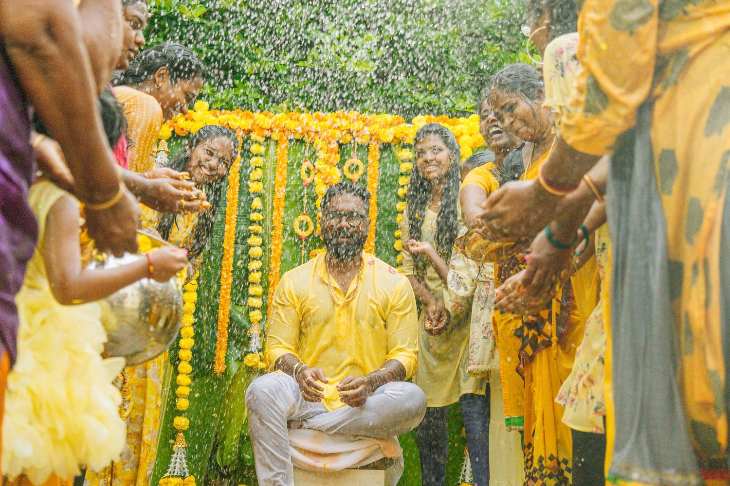 Festive celebration with yellow decorations and water ceremonies in a garden setting.