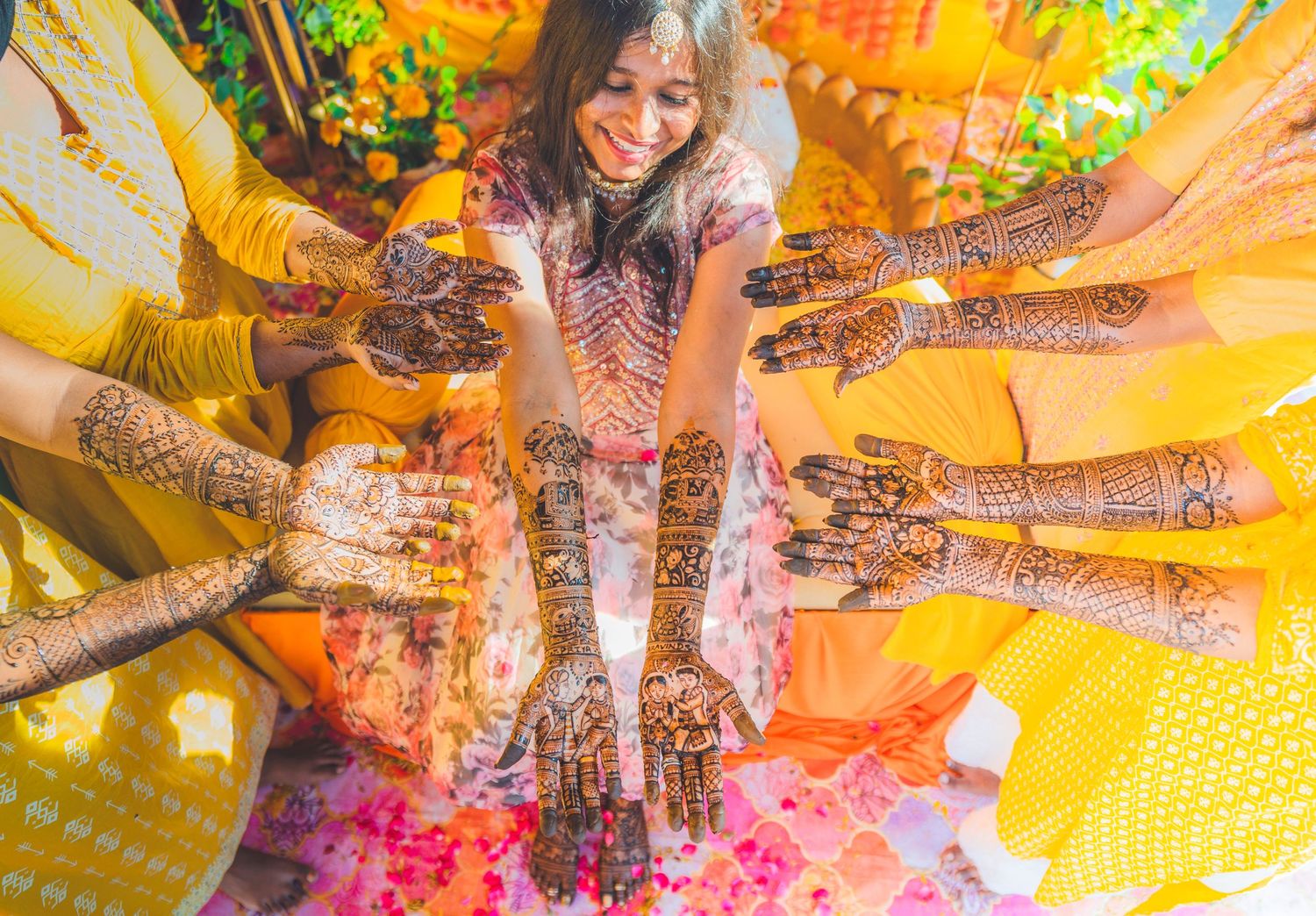 Artistic overhead shot of intricate henna designs with yellow and orange color effects.