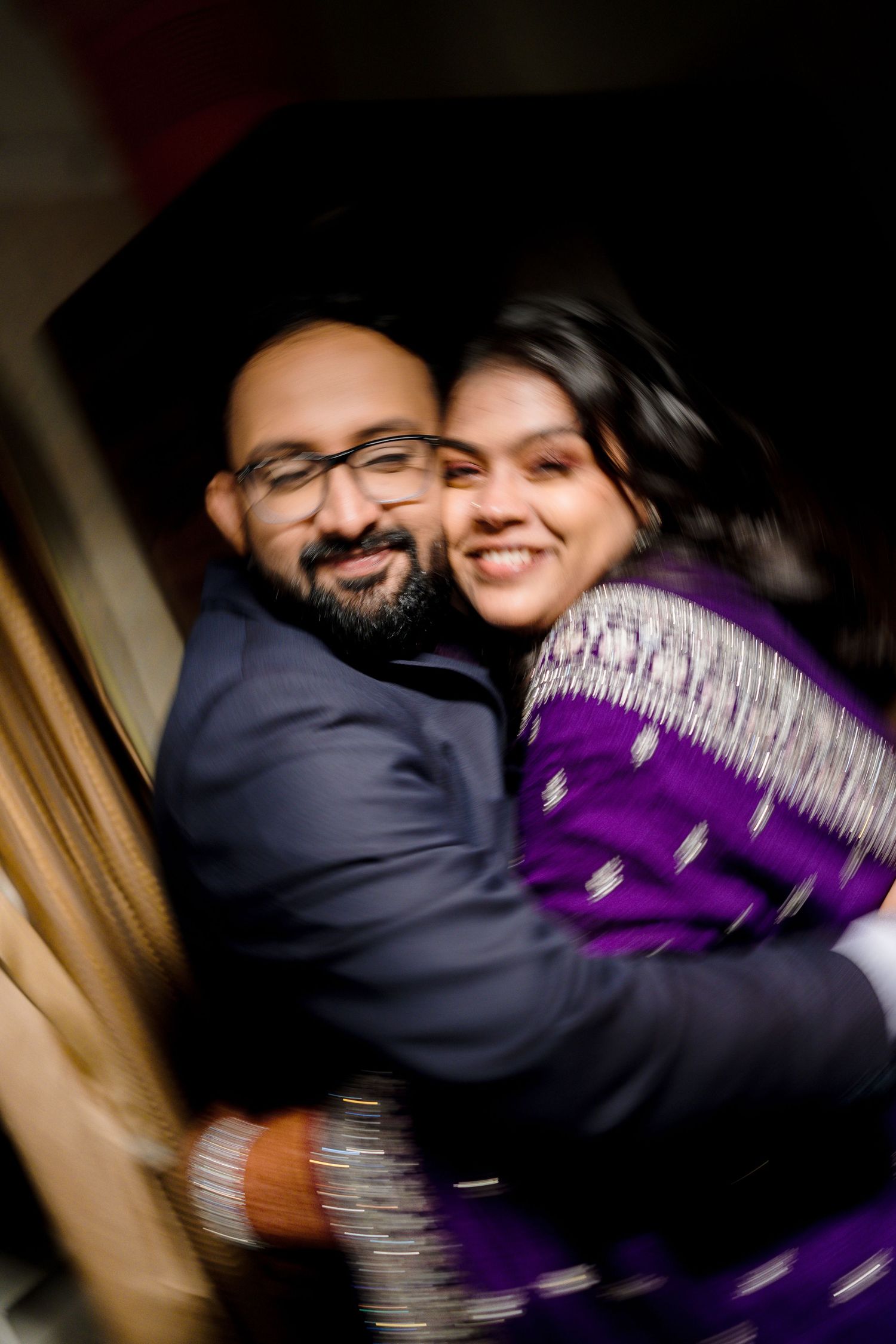A couple in dark clothing embraces and smiles in a candid sequence of romantic photos.