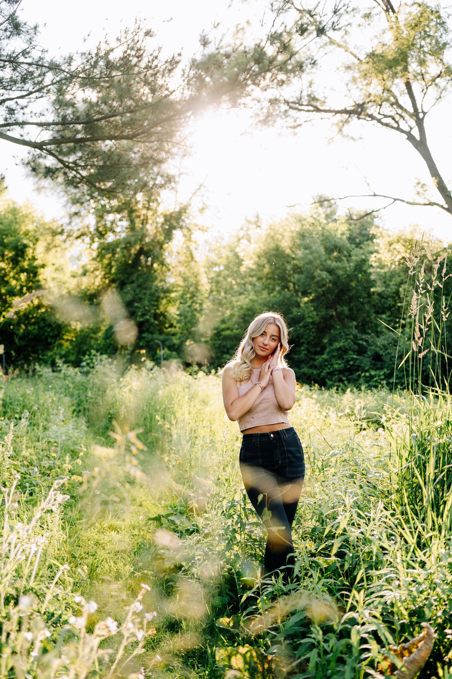 A series of outdoor photos capturing candid moments in a sunlit meadow with tall grass and trees.