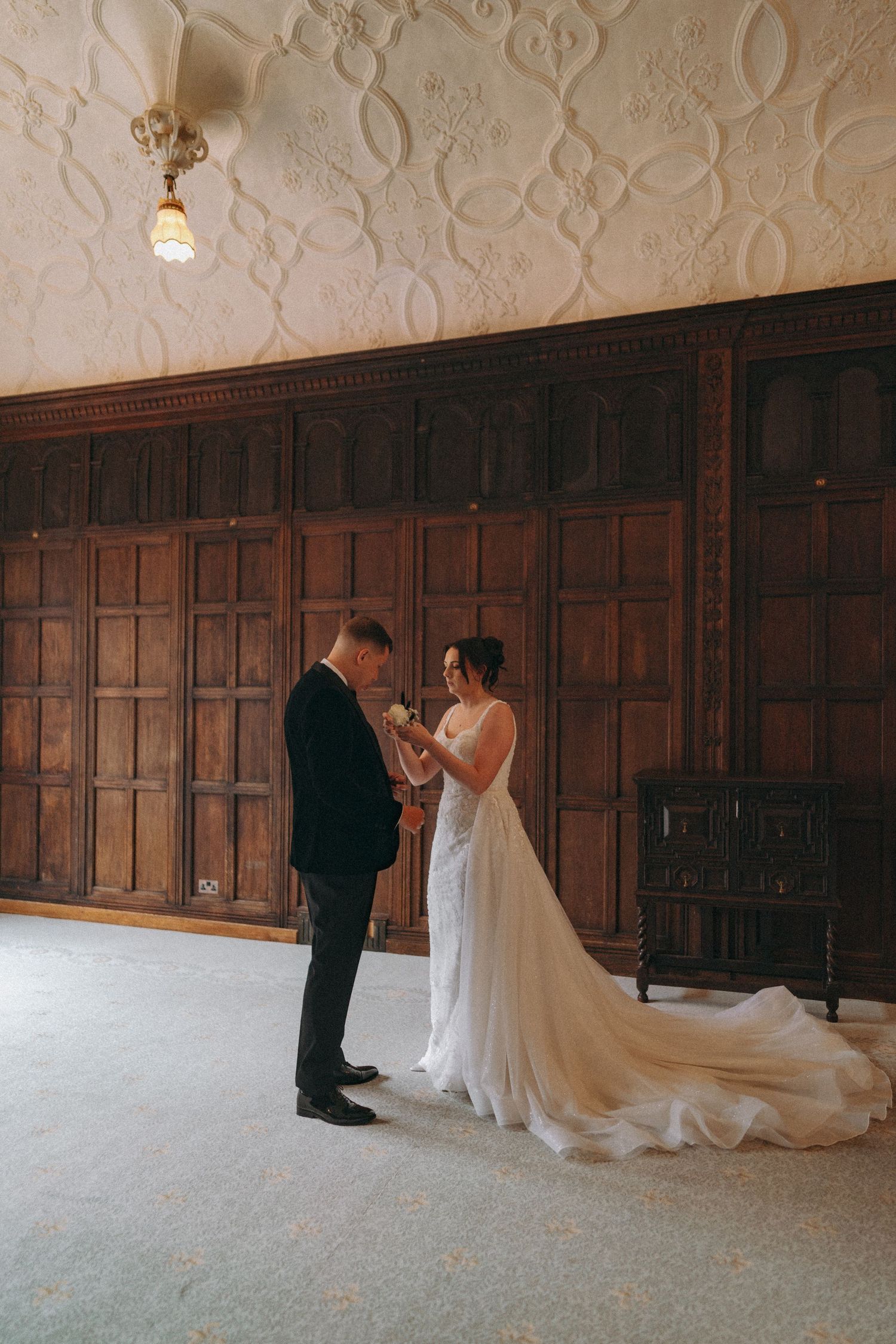 Candid moment between bride & groom as bride adjusts groom's lapel. Documentary Wedding