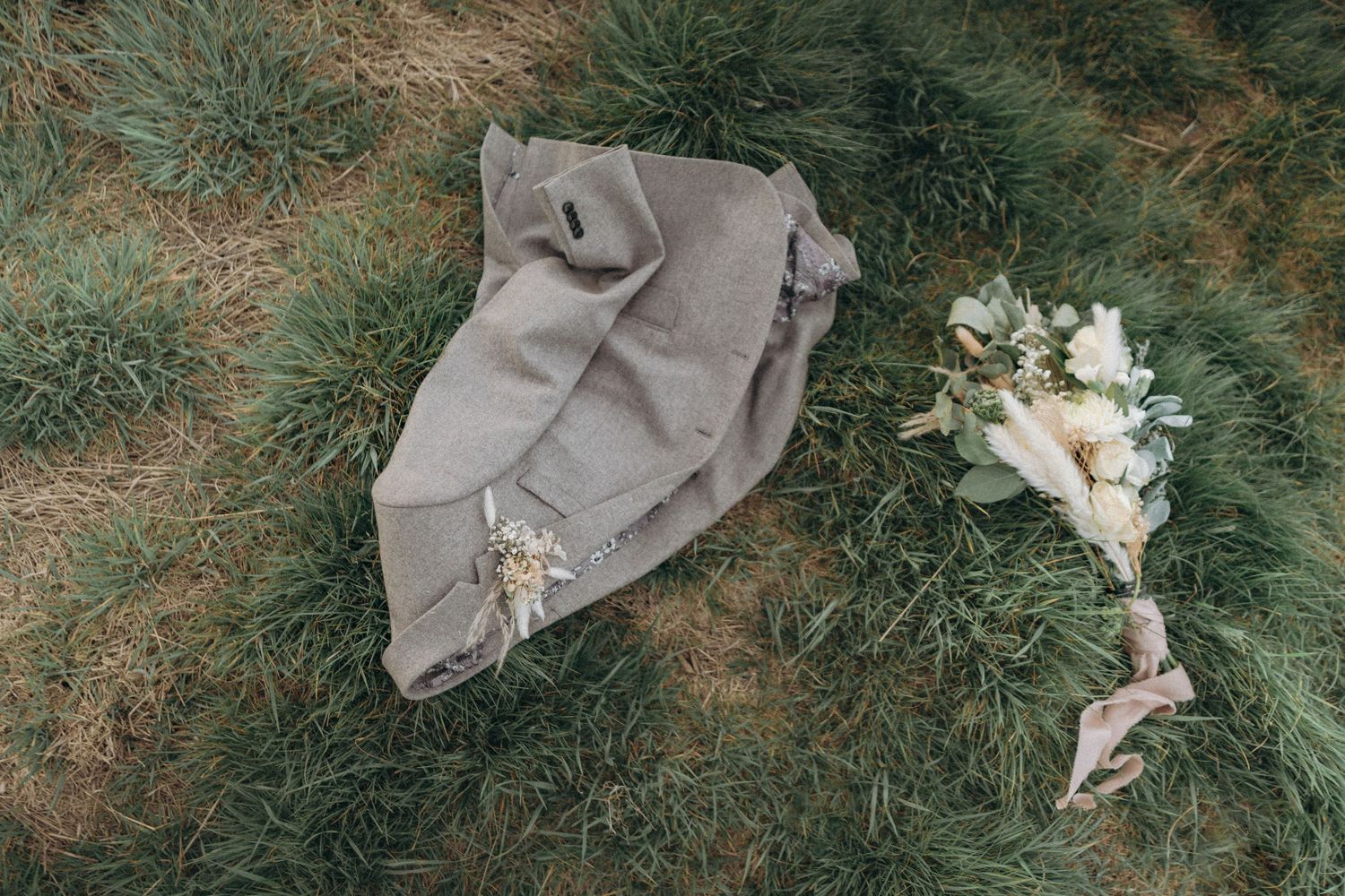 Groom blaze & bride's bouquet on a field, documentary wedding