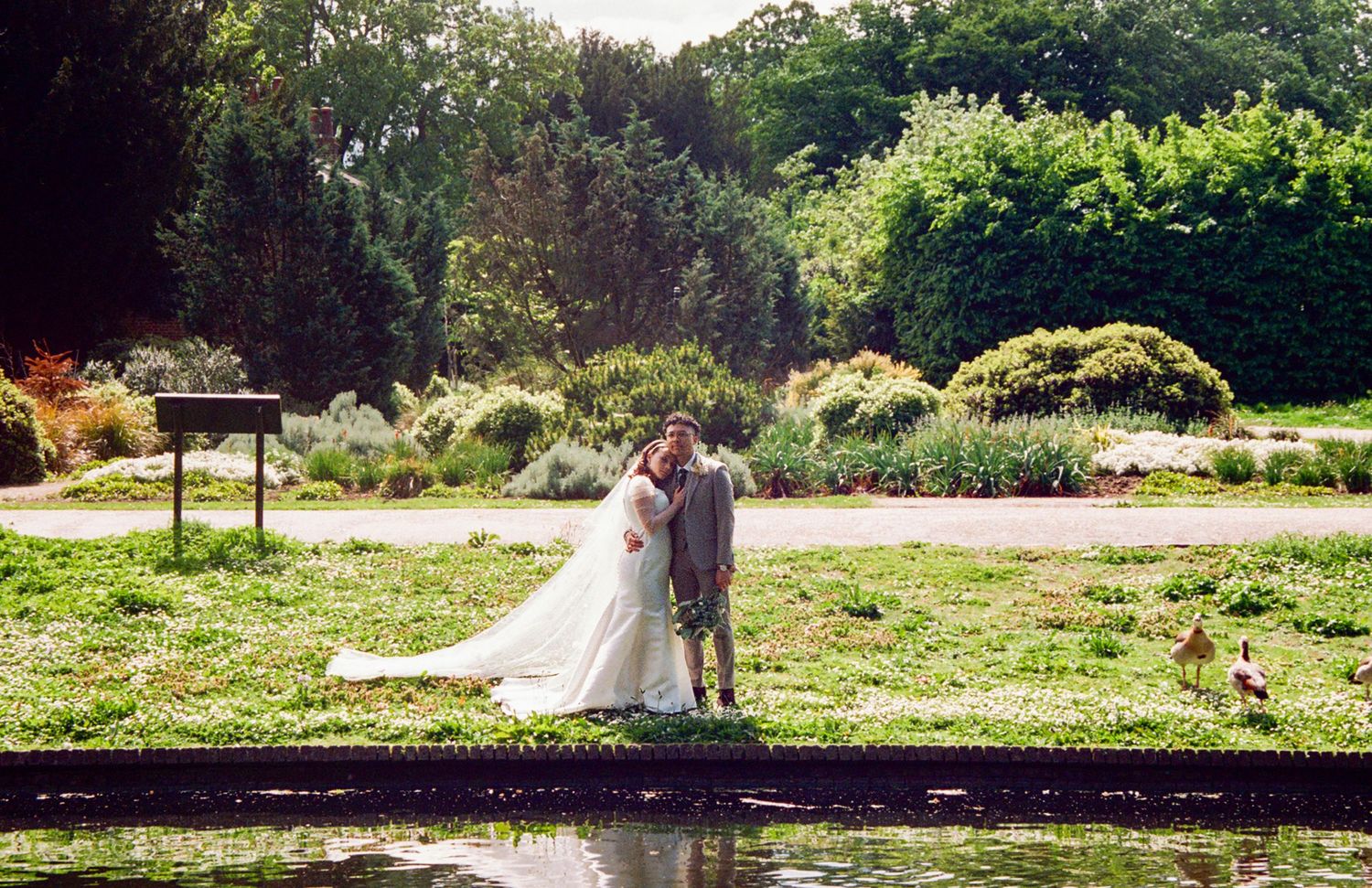 Bride & groom standing beside a canal. Documentary wedding