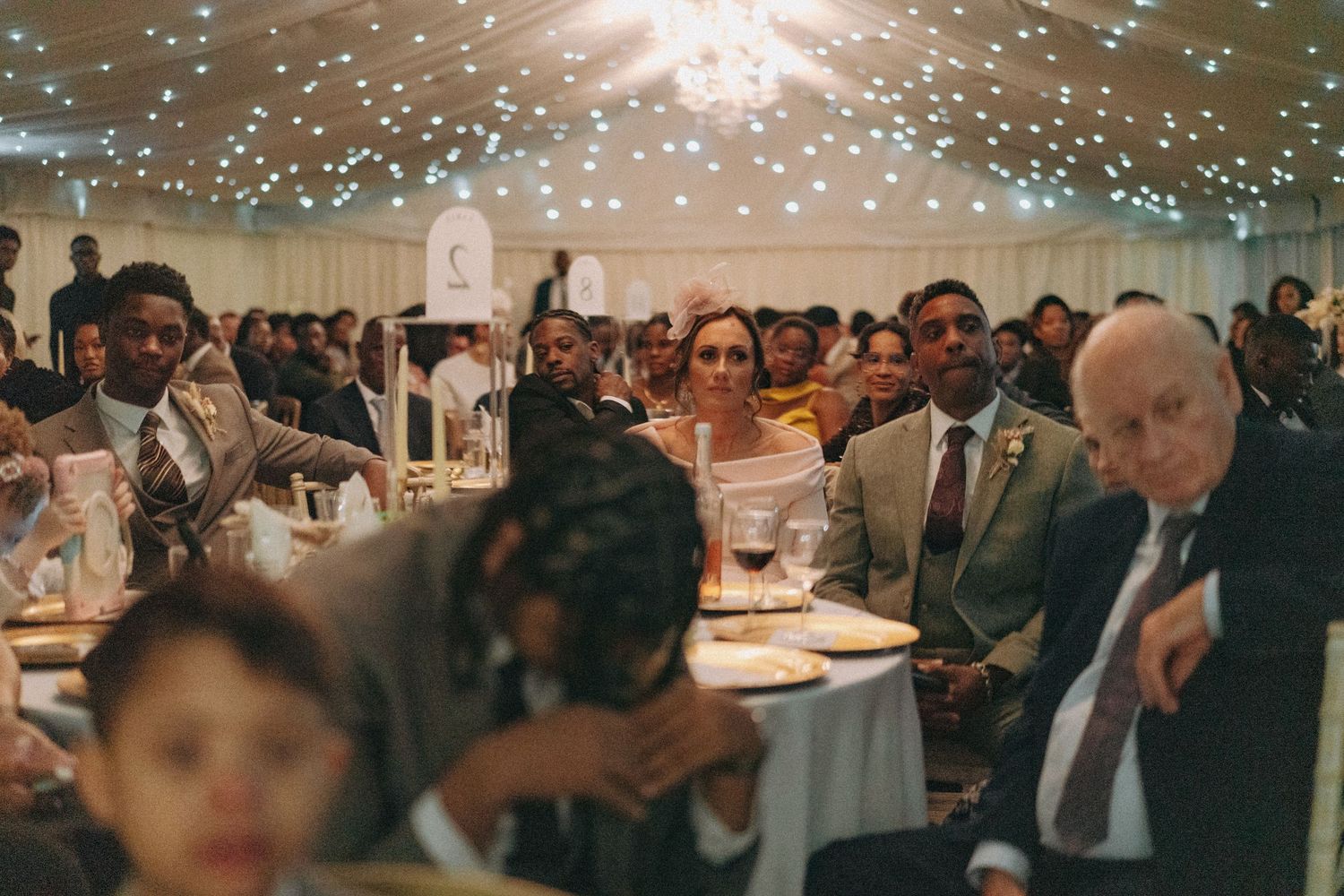 Mother of groom looking ahead solemnly, wedding reception