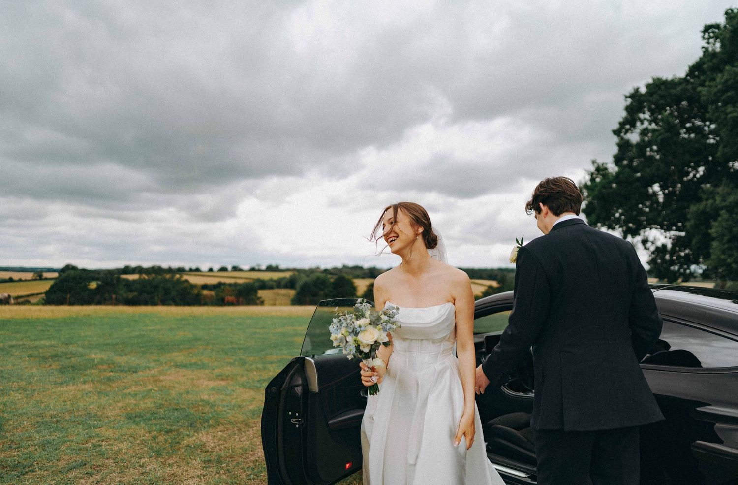 Candid of bride & groom exiting a wedding car, documentary wedding