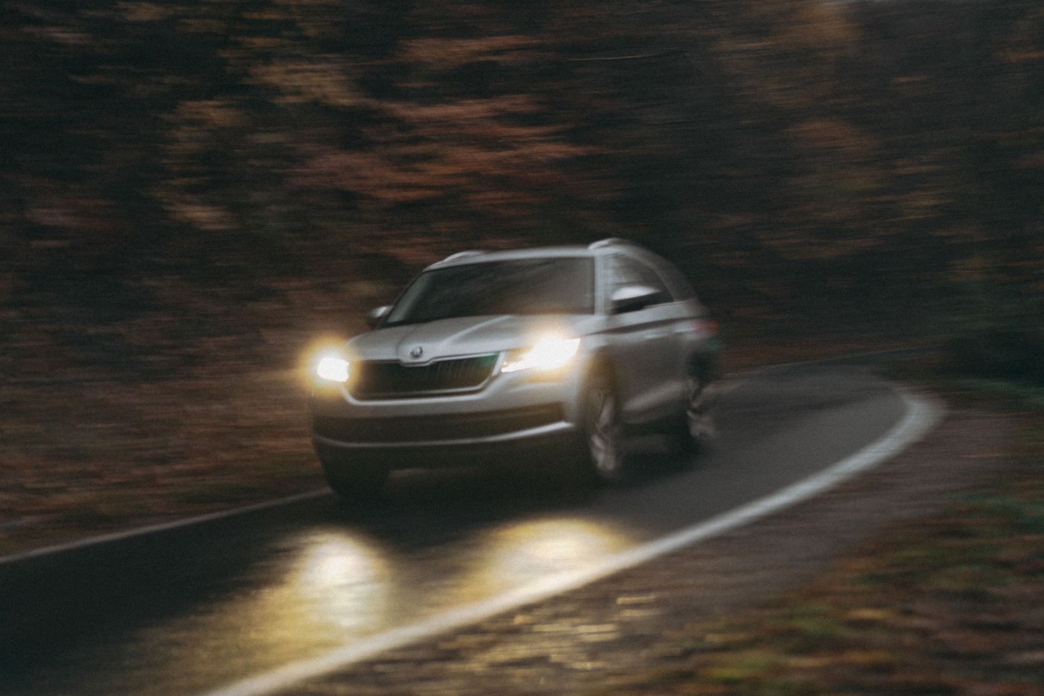 Family SUV with headlights on, driving on alpine route, Documentary family photography